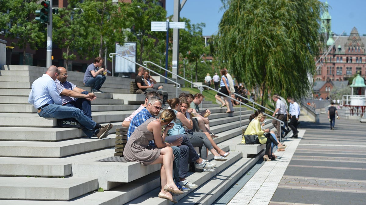  People gather for lunch on steps overlooking a waterway in HafenCity. (Wulf Rohwedder/for Keystone Crossroads) 