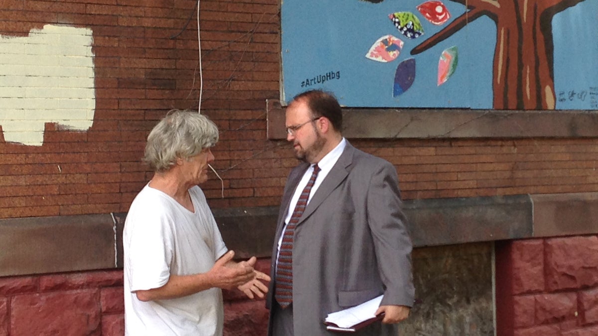  Harrisburg Mayor Eric Papenfuse talks with a city resident at an event to highlight an initiative that will board up blighted buildings with artwork.  (Emily Previti/WITF)  