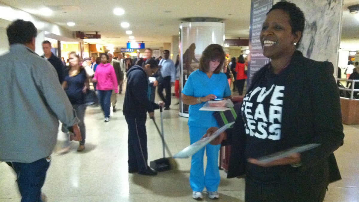  Valerie Myers, a representative from Independence Blue Cross, hands out information about health insurance during the morning commute at Philadelphia's Suburban Station.  (Elana Gordon/WHYY) 