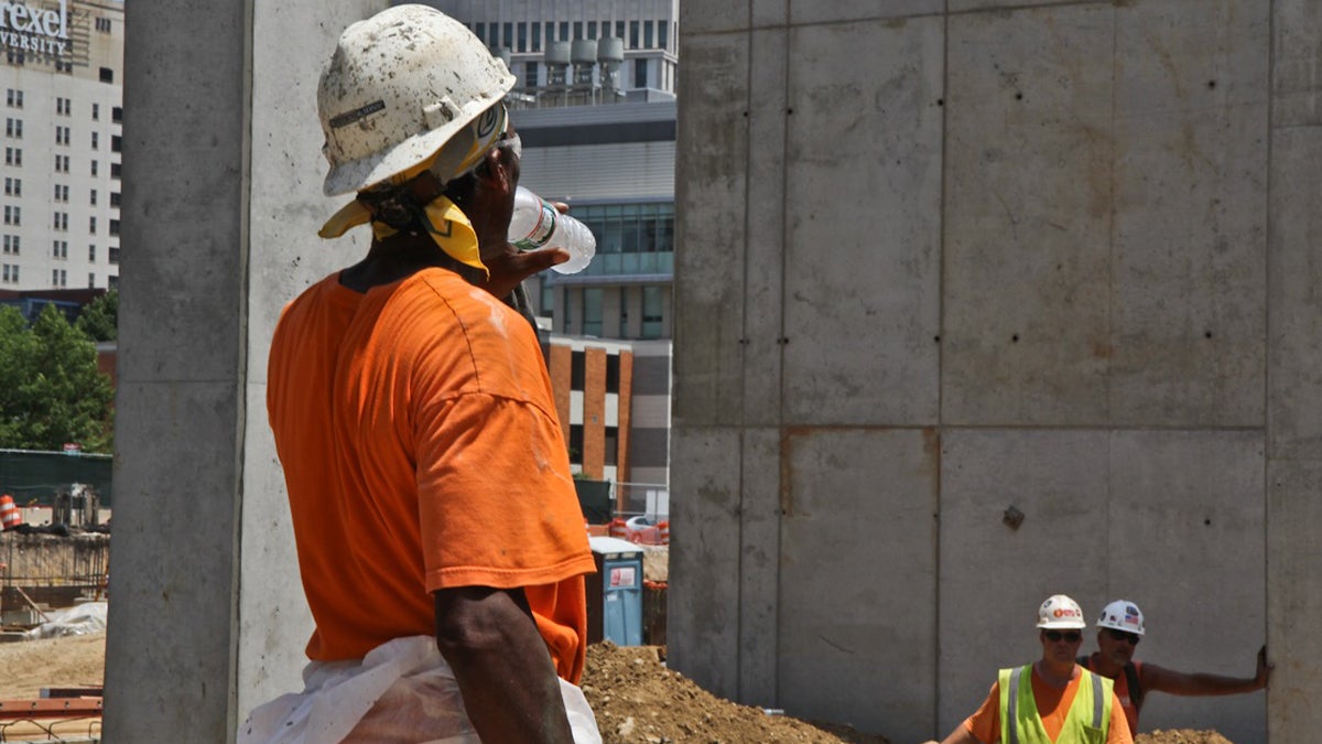  A worker pauses in the midday sun for a cool drink of water ion Philadelphia. Temperatures rose well into the 90s Wednesday.(Kimberly Paynter/ WHYY) 