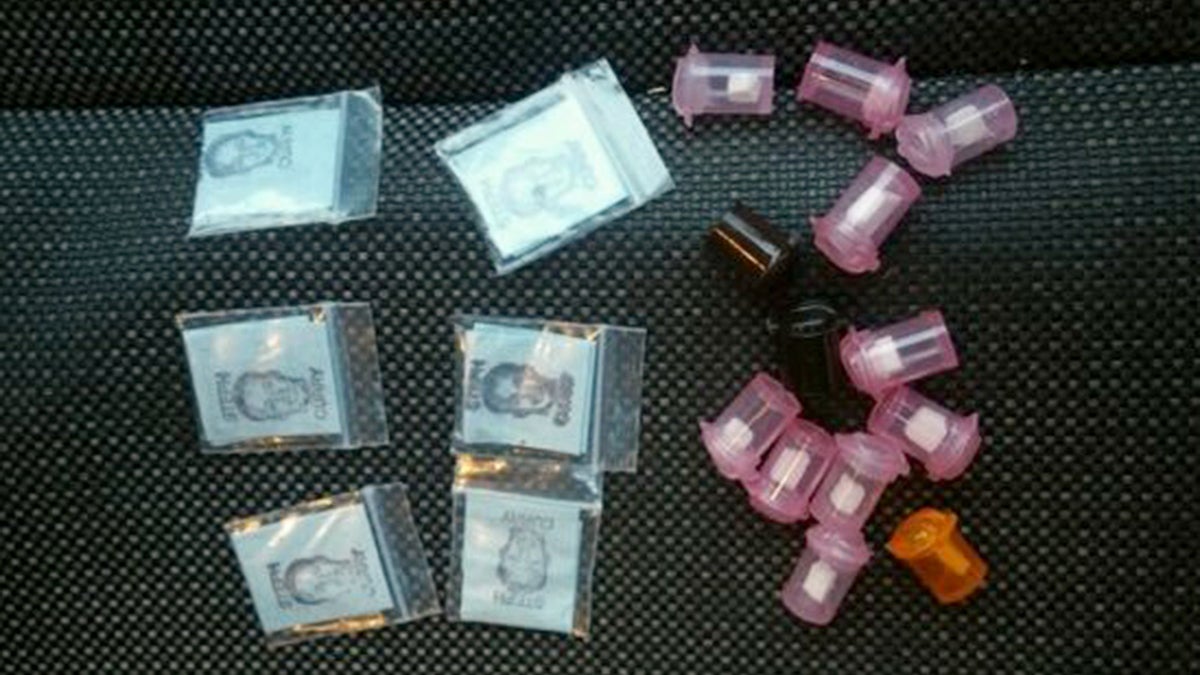 This undated photo shows packets and plastic containers of heroin confiscated in Philadelphia. (SEPTA Transit Police via AP)