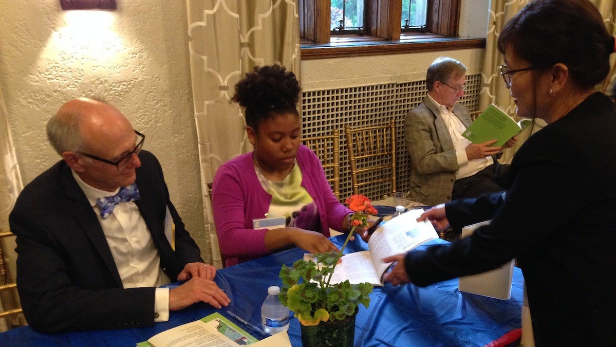 James Buehler (left) of Drexel  and a student journalist from St. Martin de Porres school sign books. (J. Woods/WHYY)