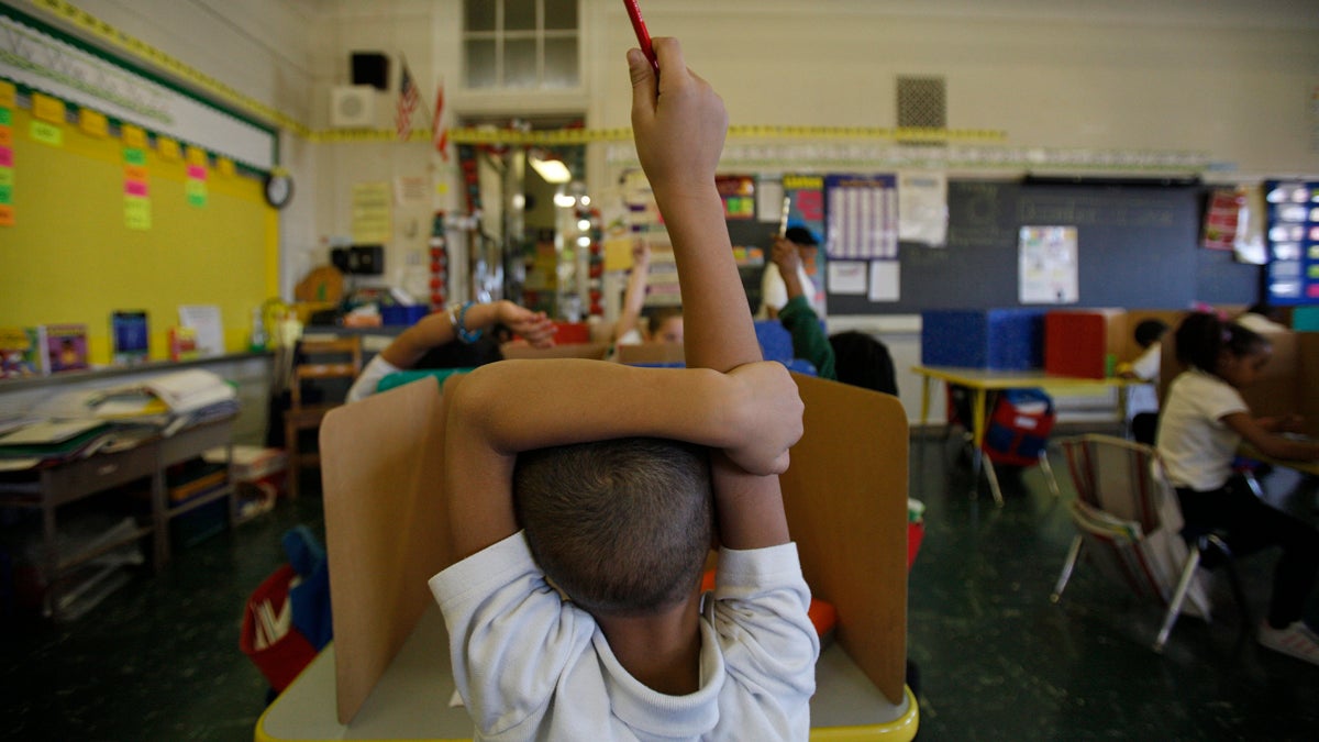  A student raises his hand at Isaac Sheppard School in Philadelphia. (Photograph by Jessica Kourkounis) 