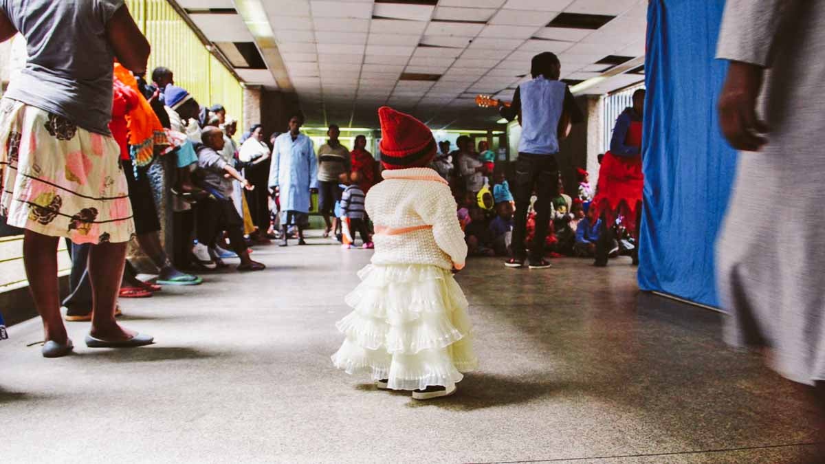  A small patient at a cancer ward in Kenya watches as clowns perform a sketch. (Brenna Daldorph/for WHYY) 