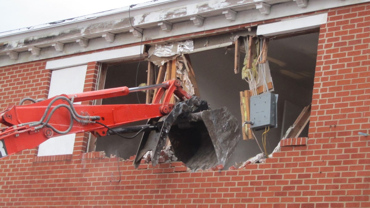  The first bulldozer hits abandoned buildings on the 800 block of Bennett on Wilmington's Eastside. (John Mussoni/WHYY) 