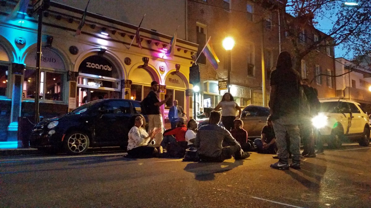 A small group protests racism in the Gayborhood by shutting down the street in front of ICandy. (Peter Crimmins/WHYY)