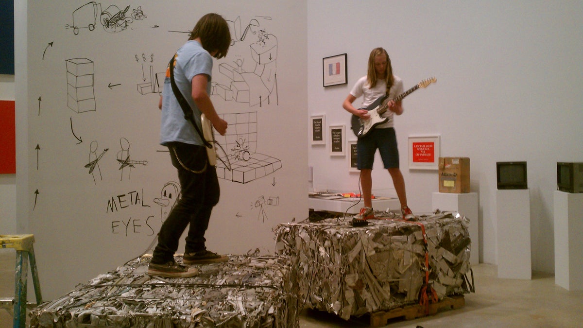  Jackson Durham (left) and Van Tingley of Metal Eyes play in a gallery at the Institute of Contemporary Art as part of a conceptual art installation by New York-based Mary Ellen Carroll. The duo stands atop bales of scrap metal that were compressed into 1-ton blocks at Revolution Recovery (in Tacony) to be sold on the scrap metal market.(Peter Crimmins/WHYY) 