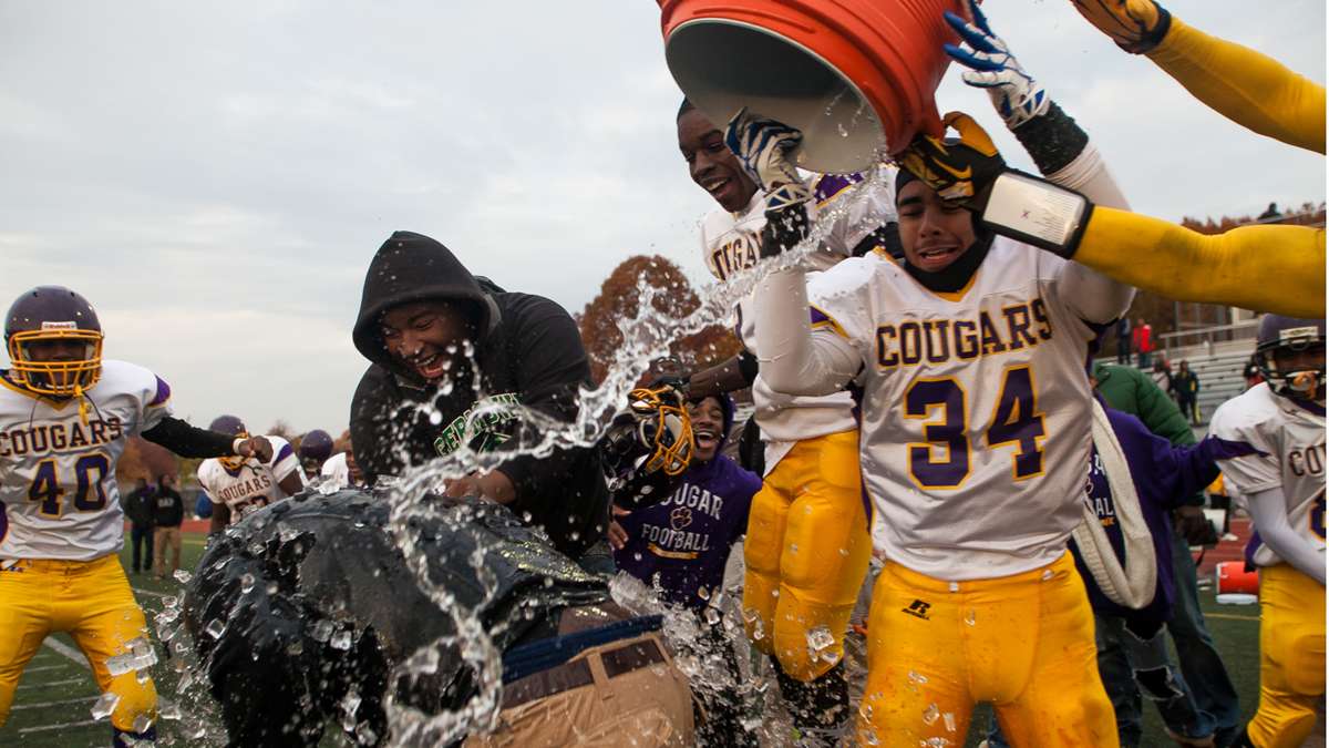  After winning the school's first-ever Public League title, MLK Cougars players doused Head Coach Ed Dunn with water to celebrate on a cold November day. (Brad Larrison/for NewsWorks) 