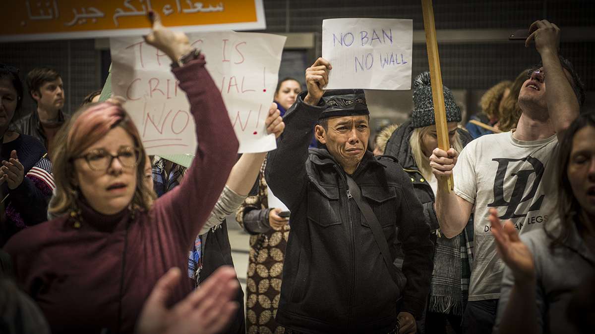 Protesters angered by President Donald Trump's 2017 executive order that prevented refugees, visa and green card holders from entering the U.S. rally at Philadelphia International Airport. (Branden Eastwood/for WHYY)
