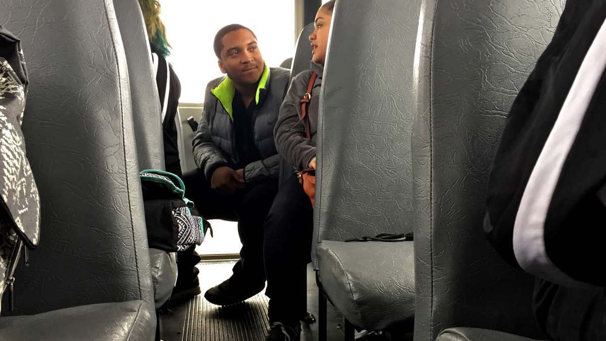 Hakeem Thompson, a Kensington Health Sciences Academy senior, chats with other students during a bus ride to Methacton.