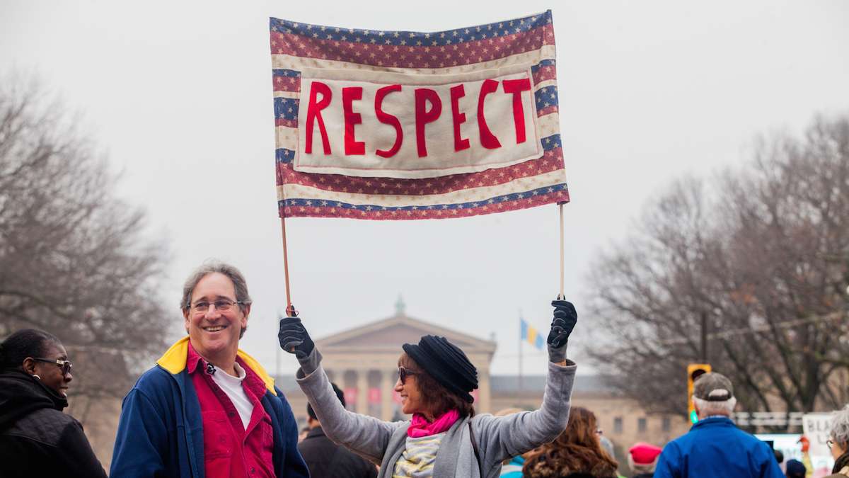 Laura Reisman-Dennis holds up a sign during the Women's March in Philadelphia Saturday morning. (Brad Larrison for WHYY)
