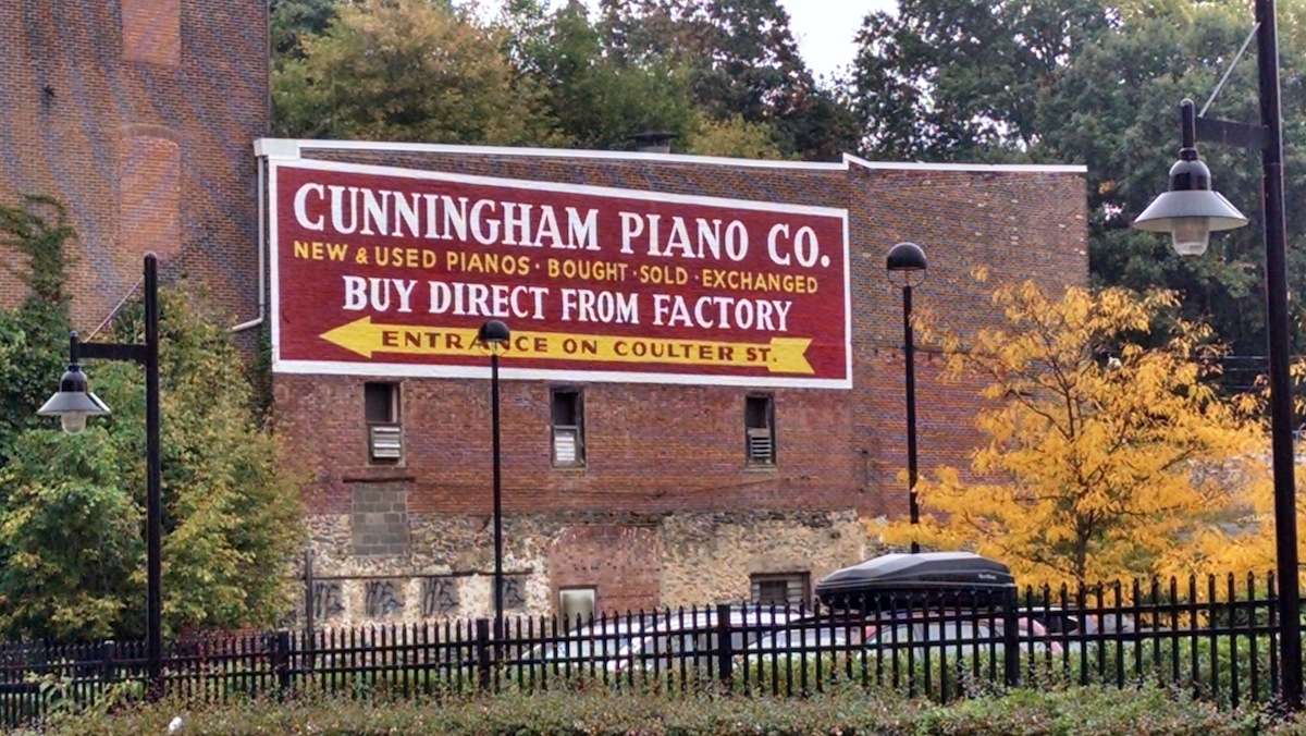  Cunningham Pianos' Coulter Street facade shows the signs still awaiting Mural Arts Program restoration. (Daniel Pasquarello/for NewsWorks) 
