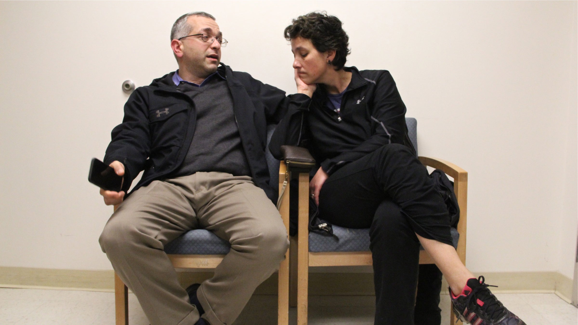 Dr. Hooman Noorchashm, a cardiac surgeon, waits with his wife, Dr. Amy Reed, an anaesthesiologist, wait in her doctor's office at Pennsylvania Hospital. (Emma Lee/WHYY)