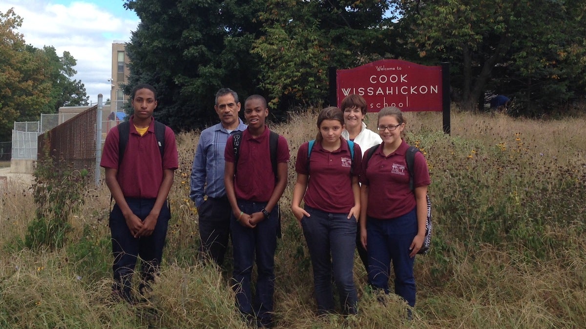  English teacher Jose Ramos and Wissahickon Sustainability Council cofounder Jeanne Ortiz stand with eighth graders in the school's native plant meadow. (Neema Roshania/WHYY) 