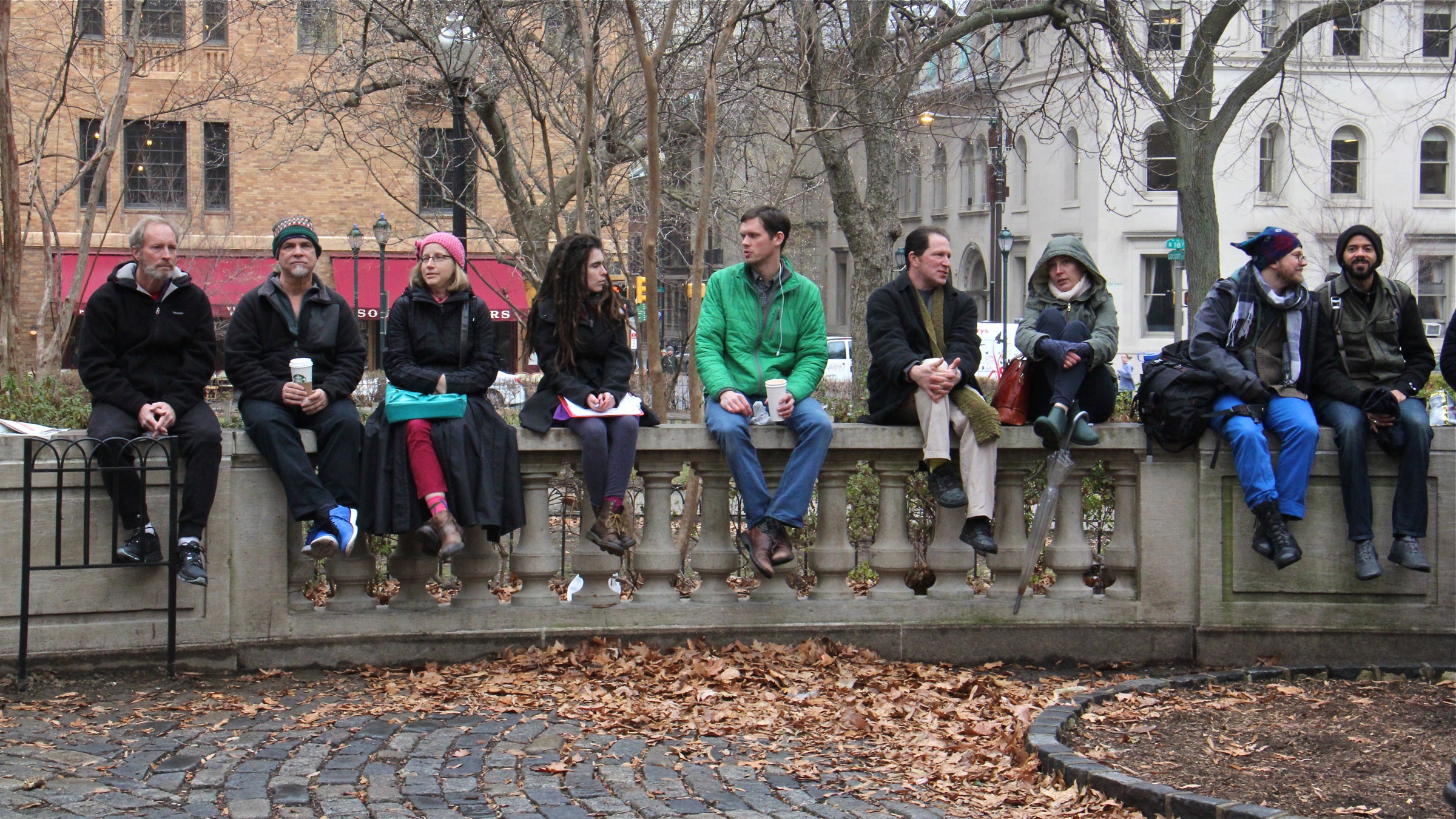 Rittenhouse Square wall-sitters celebrate the end of a brief ban with a lunch-time sit-in. (Emma Lee/WHYY)