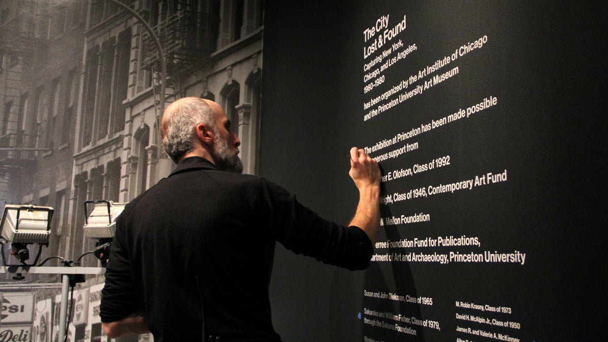 A preparer Princeton University Art Museum puts the finishing touches on The City Lost & Found, a photographic exploration of New York, Chicago, and Los Angeles from 1960 to 1980. (Emma Lee/WHYY)