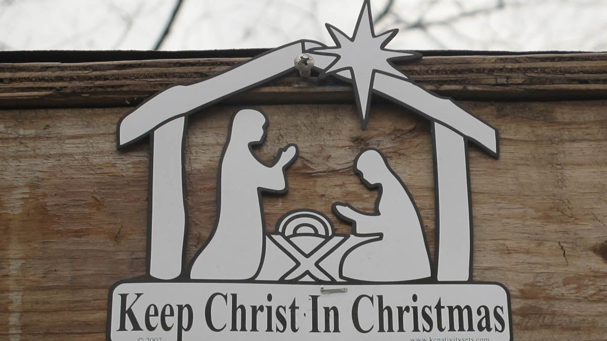 A sign above the Nativity display near the New Jersey Statehouse in Trenton. (Phil Gregory/WHYY)   