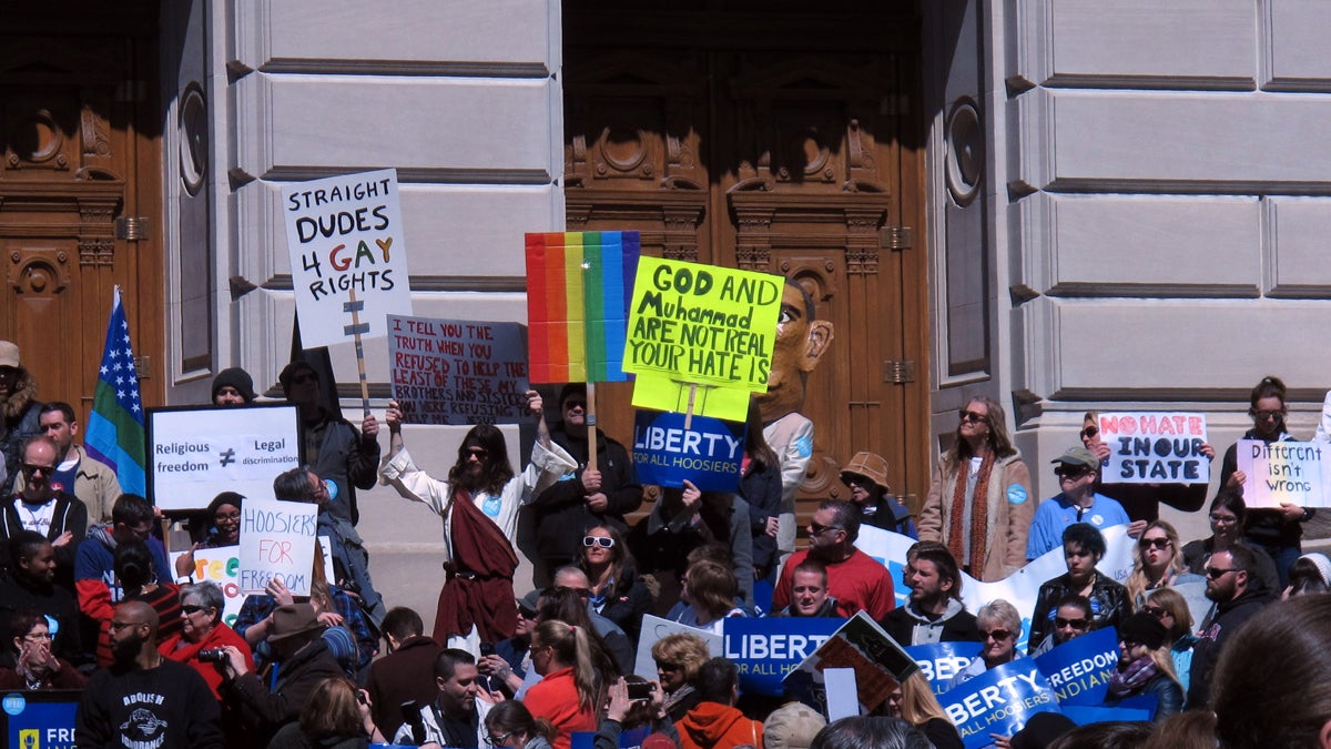  Some of the hundreds of people protesting against 'religious freedom' legislation signed last week by Gov. Mike Pence are shown standing on the Indiana Statehouse's south steps on March 28. (AP Photo/Rick Callahan) 