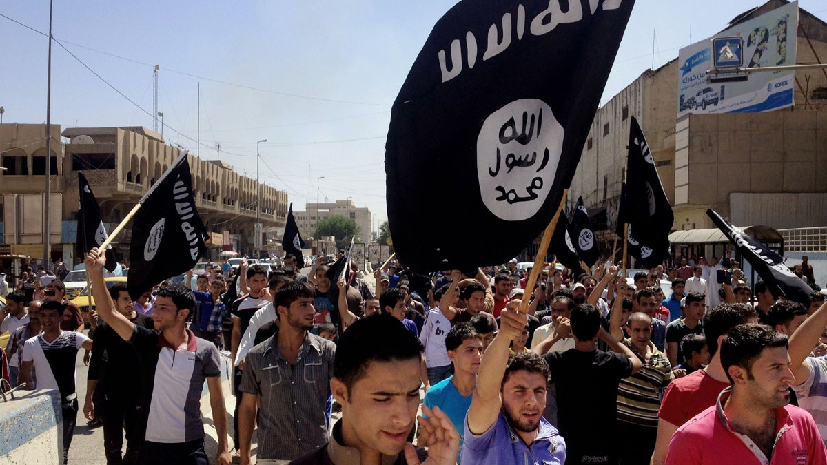  In this June 16, 2014, file photo, demonstrators chant pro-Islamic State slogans as they carry the group's flags in front of the provincial government headquarters in Mosul, 225 miles (360 kilometers) northwest of Baghdad. (AP Photo, File) 