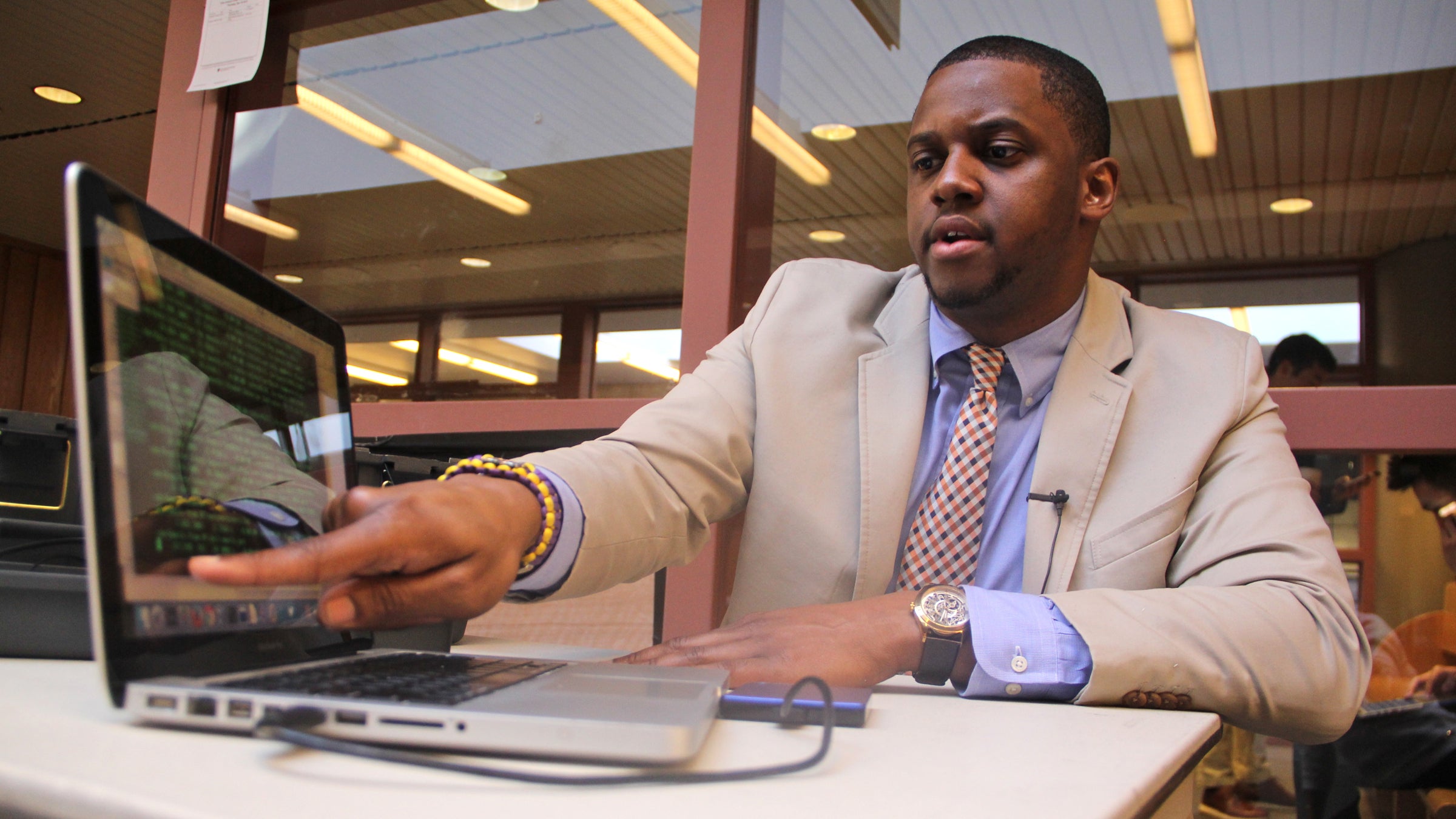 Jarrett Drake watches the scroll as digital files download to his computer. (Emma Lee/WHYY)