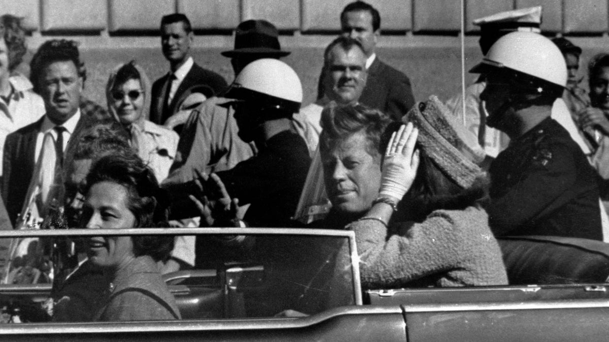  President John F. Kennedy is seen riding in a motorcade approximately one minute before he was shot in Dallas, Tx., on Nov. 22, 1963. In the car riding with Kennedy are Mrs. Jacqueline Kennedy, right, Nellie Connally, left, and her husband, Gov. John Connally of Texas. (AP Photo) 