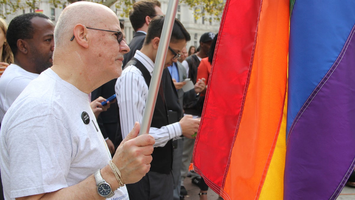  John Speer of Philadelphia carries a rainbow flag to Love Park in Philadelphia on Thursday for an announcement from state reps. Brian Sims and Steve McCarter about the introduction of a same-sex marriage bill in Pa. (Emma Lee/for NewsWorks) 
