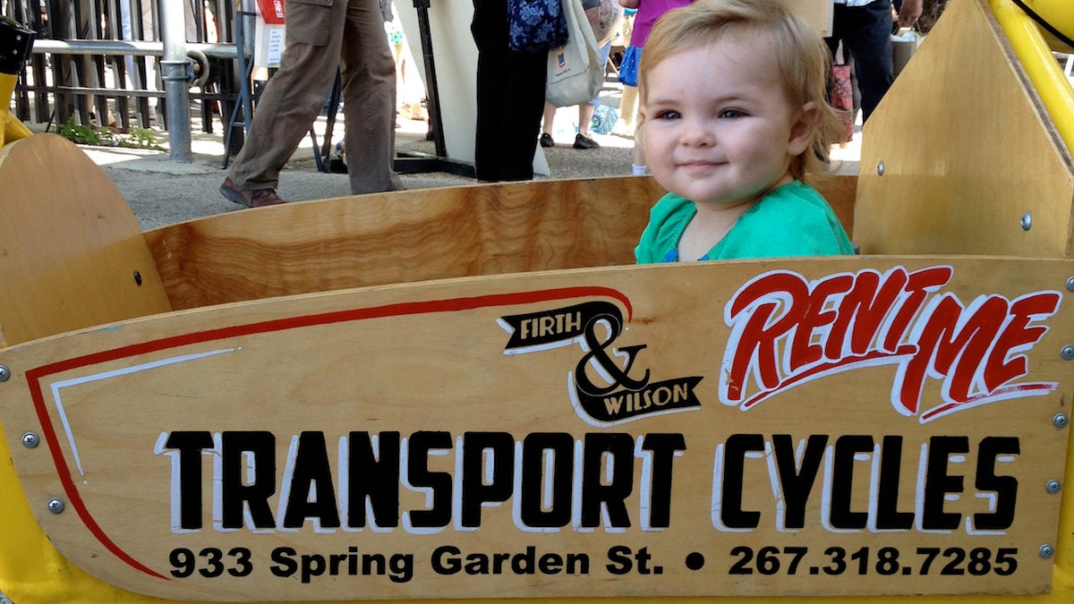 Juniper Driscoll in a cargo bike at Firth & Wilson. (Dena Driscoll/for NewsWorks)