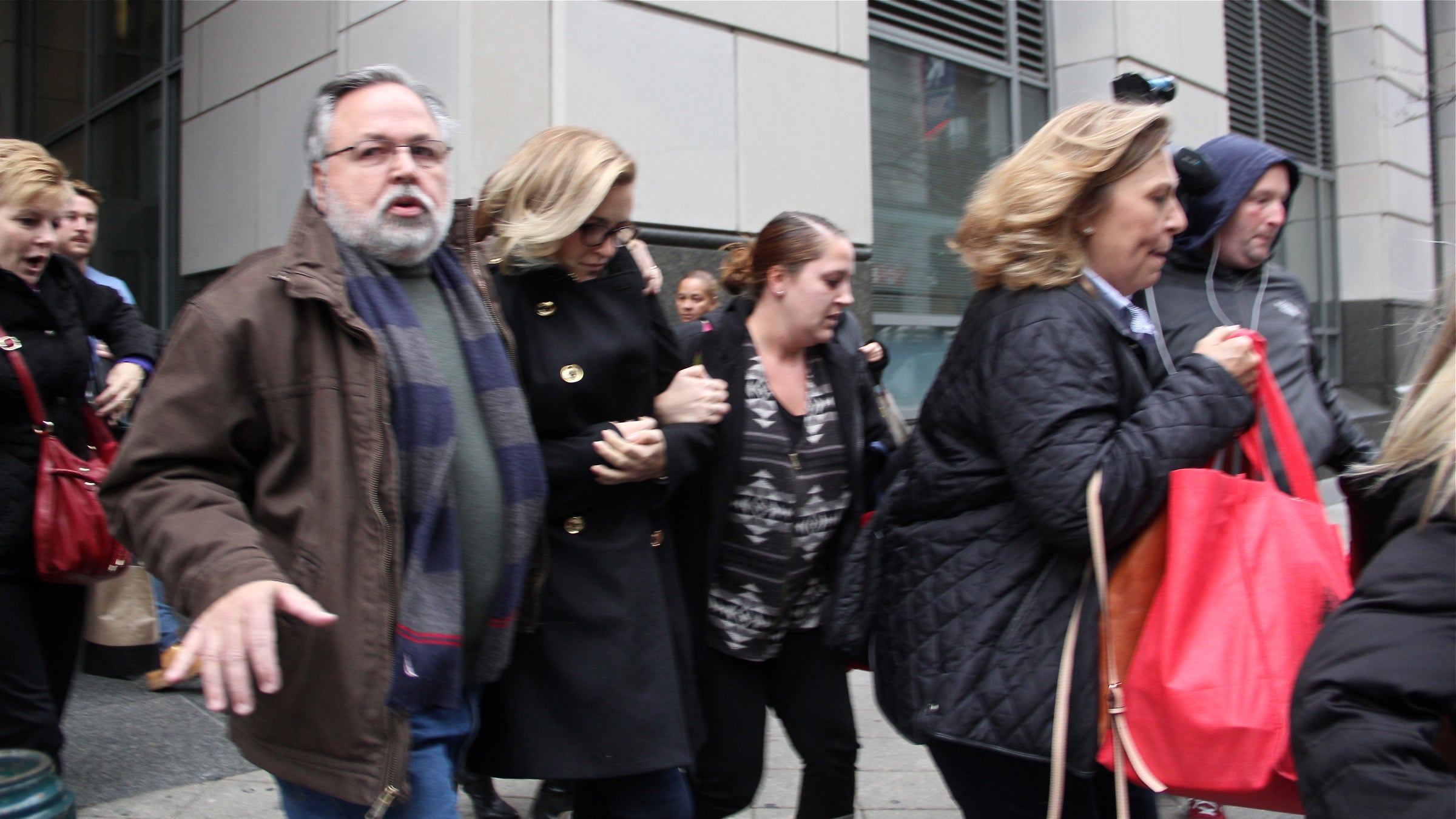 Supporters of Kathryn Knott hustle her from the courthouse after she was convicted of assault for her role in the beating of a gay couple in Center City.  (Emma Lee/WHYY)