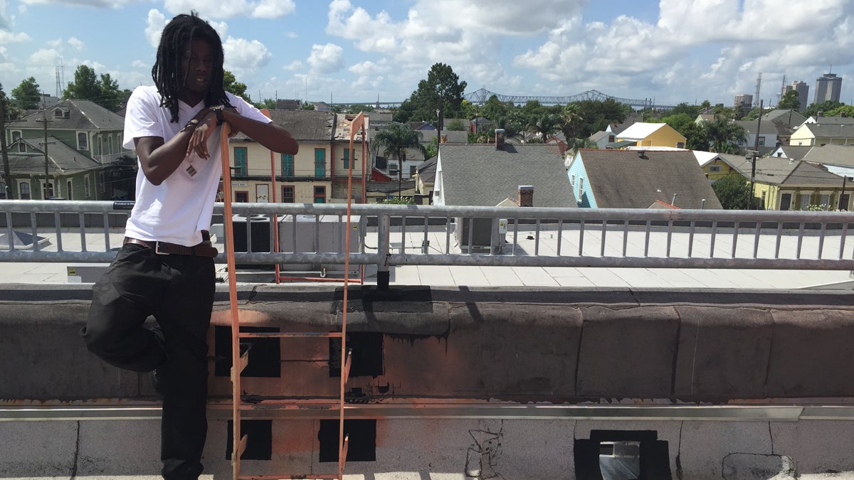 Kendall Hooker stands on the roof of the New Orleans Healing Center in the city's Marigny neighborhood. Behind him is the edge of the skyline