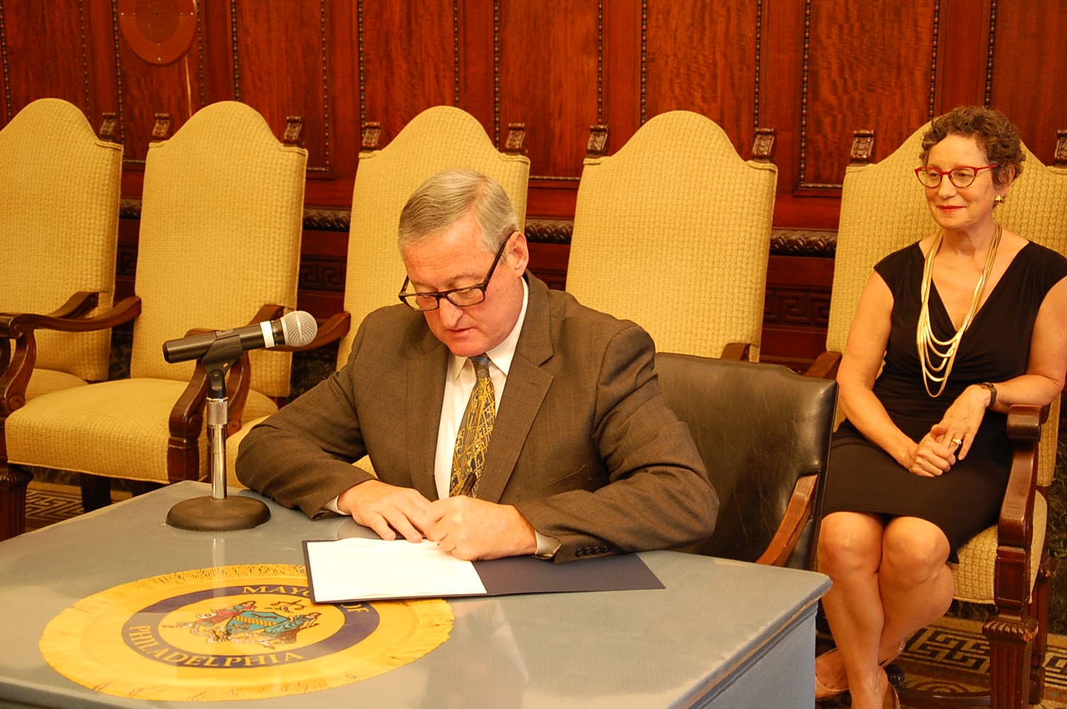 Mayor Kenney signs the executive order as Liz Hersh