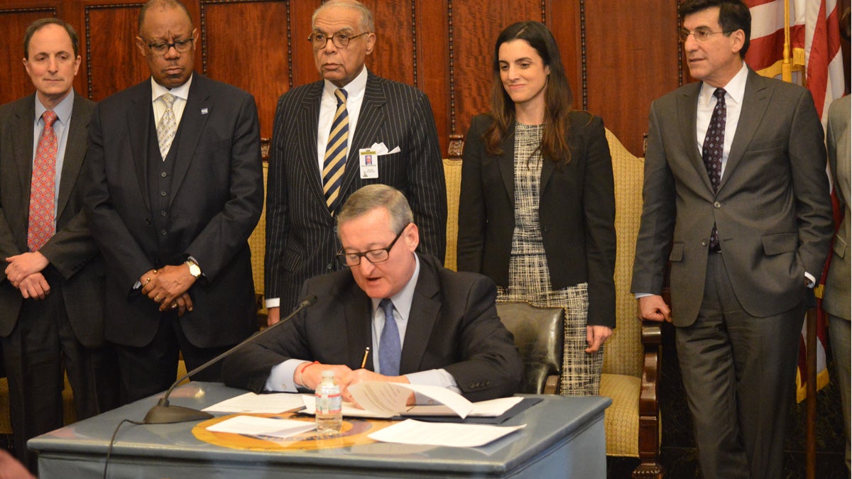  Philadelphia Mayor Jim Kenney signs several executive orders yesterday just hours after taking the oath of office. (Tom MacDonald/WHYY) 