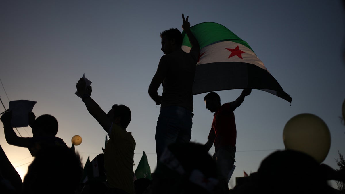  Syrian protesters wave the Syrian revolutionary flag during a protest in front of the Syrian embassy in Amman, Jordan, Friday, Aug. 23, 2013.  Anti-government activists accused the Syrian regime of carrying out a toxic gas attack that is thought to have killed at least 100 people, including many children. (AP Photo/Mohammad Hannon) 