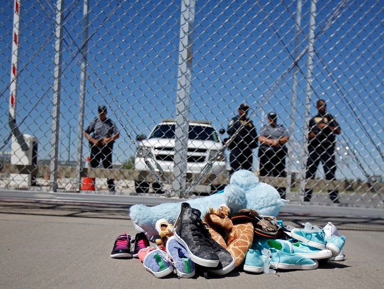 Shoes and a teddy bear, brought by a group of U.S. mayors, are piled up outside a holding facility for immigrant children in Tornillo, Texas, near the Mexican border, Thursday, June 21, 2018.  Mayors from more than a dozen U.S. cities including New York and Los Angeles gathered near the holding facility to call for the immediate reunification of immigrant children with their families (Andres Leighton/AP Photo)