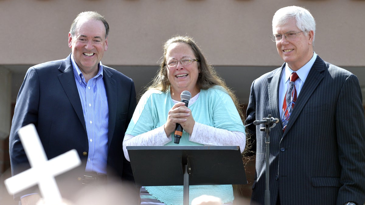  Rowan County Clerk Kim Davis, center with Republican presidential candidate Mike Huckabee, left, and attorney Mat Staver, right, founder of the Liberty Counsel, the Christian law firm representing Davis, at her side, greets the crowd after being released from the Carter County Detention Center, Tuesday, Sept. 8, 2015, in Grayson, Ky. (AP Photo/Timothy D. Easley) 