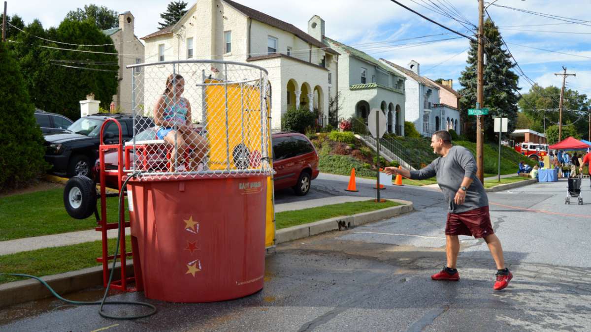  Mount Penn resident Jeff Motes lobbed a ball at the dunk tank target (and subsequently soaked his niece). He says a consolidation between Mount Penn and Lower Alsace would be 'great for the kids. The borders are so close, sharing resources would be a good thing.' (Kate Lao Shaffner/WPSU) 