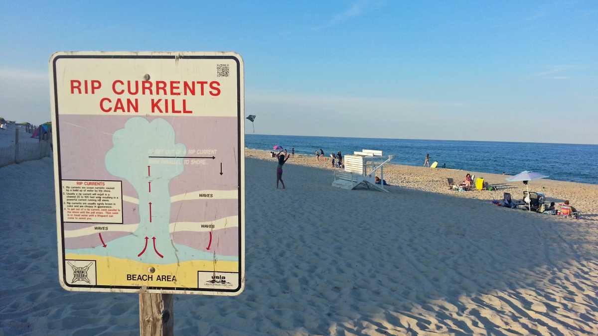 A sign in Cape May instructs swimmers caught in a rip current to swim parallel to the beach to escape. (Alan Tu/WHYY)