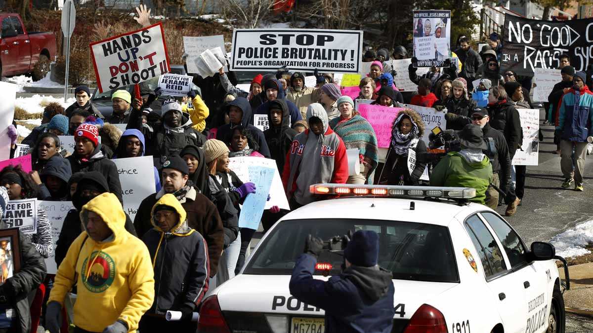  Demonstrators hold signs and shout as they march in protest of a fatal police shooting February 2015 in Bridgeton, NJ.(AP Photo/Mel Evans) 