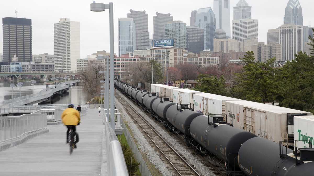  In April, a cyclist rides by train tank cars with placards indicating petroleum crude oil standing idle on the tracks in Philadelphia. Gov. Tom Wolf today released a study commissioned earlier this year to make recommendations on preventing oil train accidents in Pennsylvania. (AP Photo/Matt Rourke) 