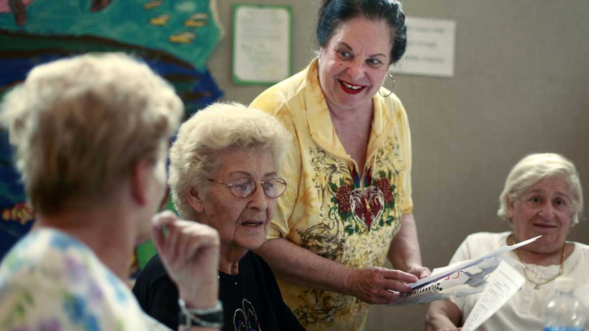 Social worker Roberta Marzano with Caring People Alliance speaks with seniors at the Fels South Philadelphia Community Center in Philadelphia