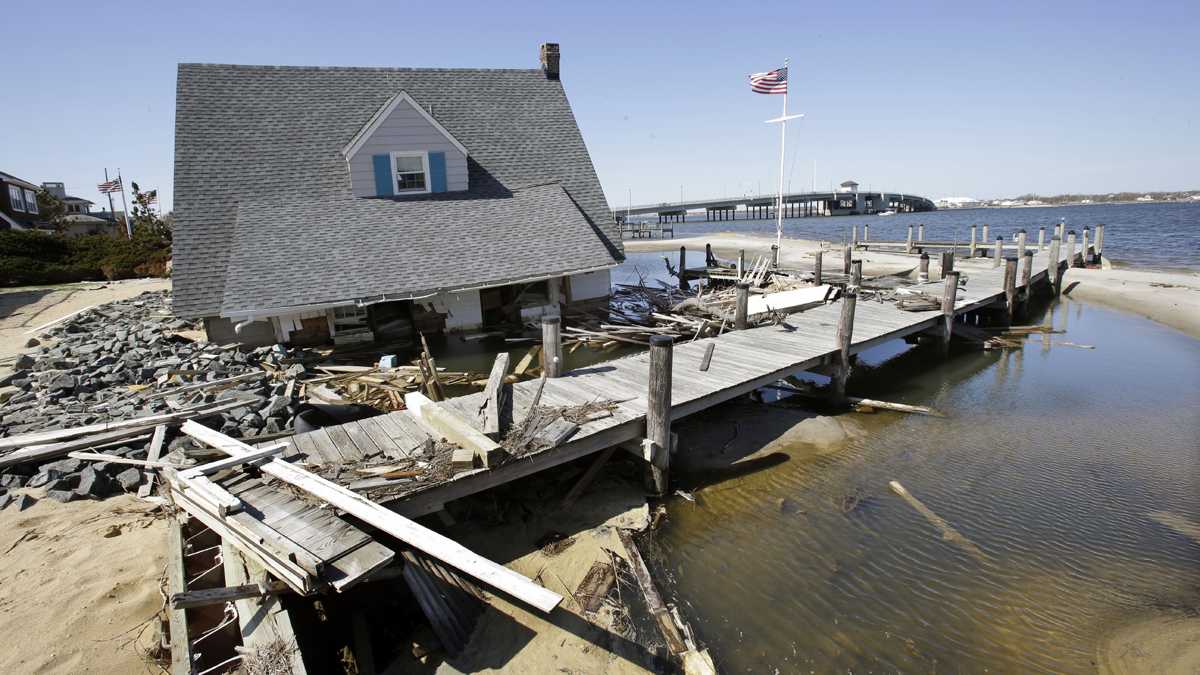  A home rests next to a pier in Barnegat Bay near the Mantoloking Bridge in Mantoloking, New Jersey, after it was swept away  by Superstorm Sandy in 2012. (Mel Evans/AP Photo)  