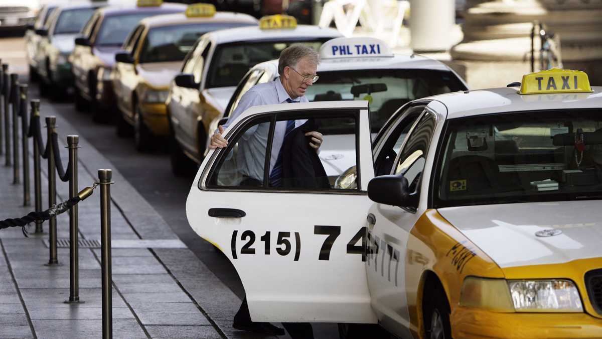 A man climbs into a cab at the 30th Street Station in Philadelphia. (Matt Rourke/AP Photo