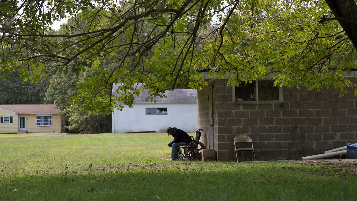  A resident sits outside of R & M guest home, a boarding home in Chesilhurst, New Jersey. (Lindsay Lazarski/WHYY) 