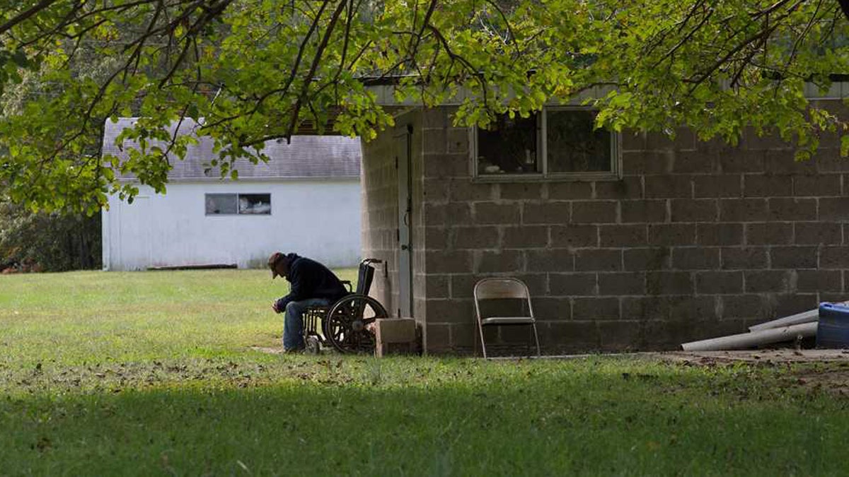  A resident sits outside of R & M guest home, a boarding home in Chesilhurst, New Jersey. (Lindsay Lazarski/WHYY)  