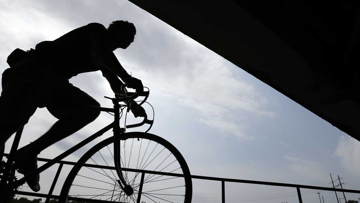 A cyclist rides beneath an overpass along the Schuylkill River in Philadelphia. (AP Photo/Matt Rourke