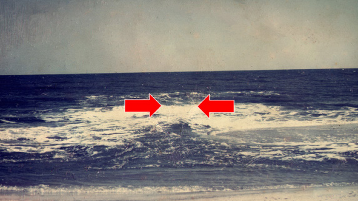  In this NOAA photo, the rip current is surging seaward in the area between the red arrows. 