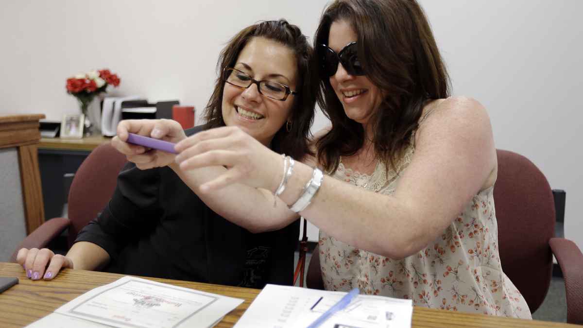  Tamara Davis, left, and Nicola Cucinotta snap a photograph of the marriage license they obtained at a Montgomery County office despite a state law banning such unions, Wednesday, July 24, 2013, in Norristown, Pa. Five same-sex couples have obtained marriage licenses in the suburban Philadelphia county that is defying a state ban on such unions.  (AP Photo/Matt Rourke) 