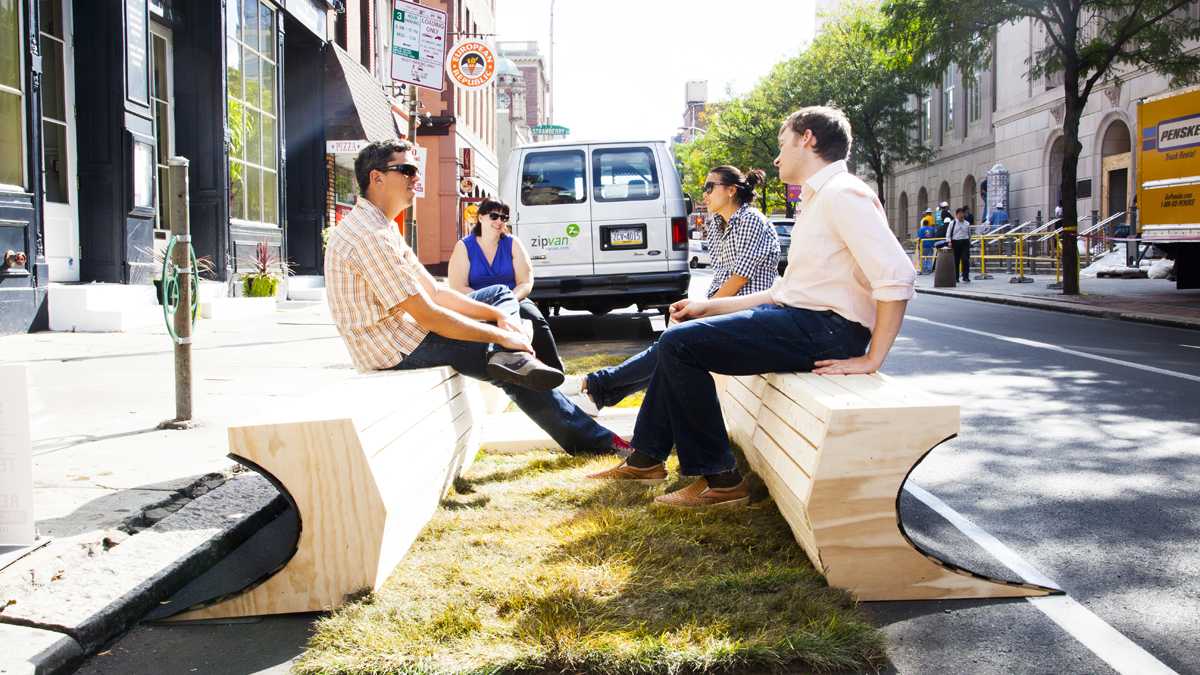 People sit at a 'parklet,' a parking spot converted into mini-park, on 3rd Street and Market Street in Philadelphia. (Brandon Reynolds/for NewsWorks) 