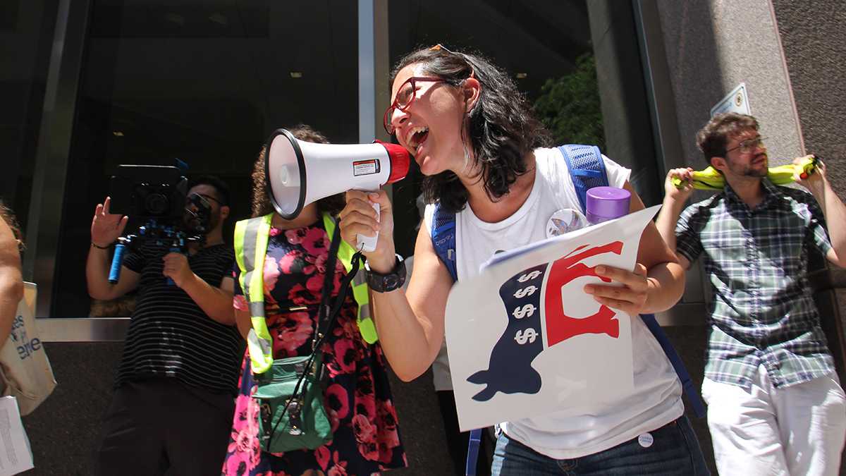 Xelba Gutierrez leads a protest  demanding that the Democratic National Convention reveal its sources of funding. (Emma Lee/WHYY)