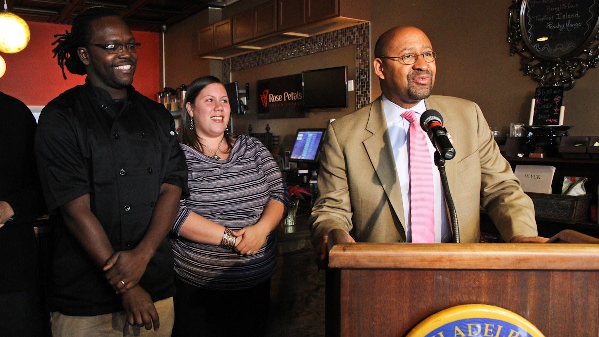  Desmin and Jania Daniels, owners of Rose Petals Cafe in Germantown, look on as Mayor Michael Nutter talks about the 