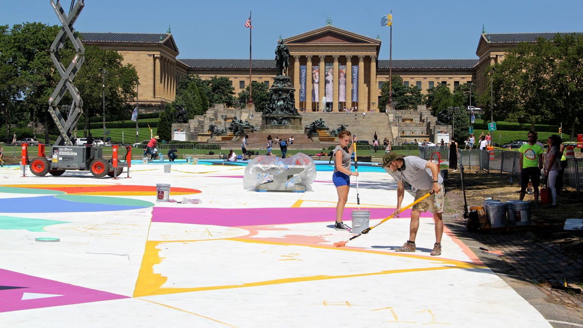 Mural Arts painters are busy transforming Eakins Oval into a colorful play place for the summer. (Emma Lee/WHYY)